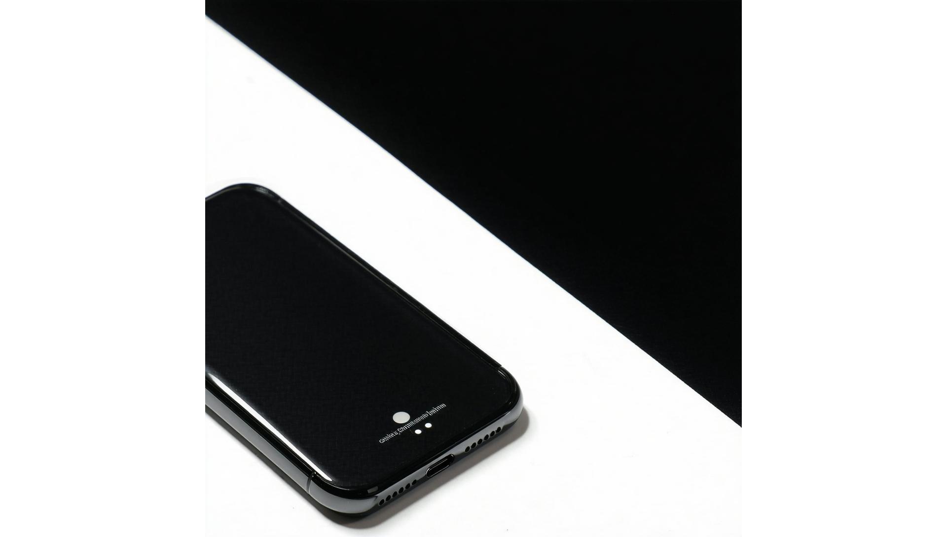 A minimalist phone case alongside a wireless charger on a clean, modern surface.